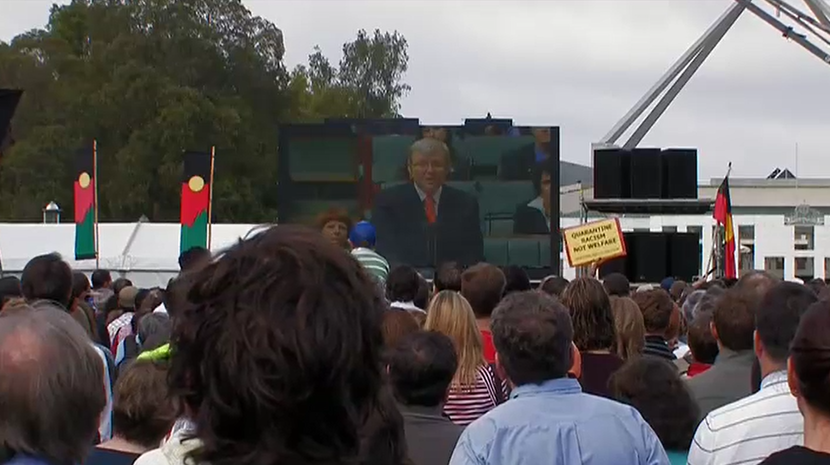 On 13 February 2008 crowds gathered in Australian capital cities to watch Prime Minister Kevin Rudd deliver The Apology to the Stolen Generations live from the House of Representatives at Australian Parliament House. This crowd is watching from the lawns in front of Australian Parliament House. Still from Emily in Japan – The making of an exhibition 2009. Courtesy Ronin Films.